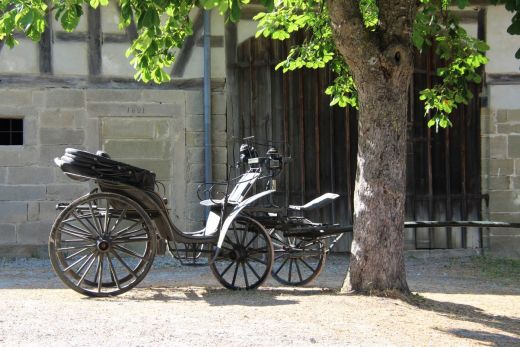 Alte Kutsche vor einem Gebäude aus dem 19. Jahrhundert – ein Blick auf historische Transportmittel.